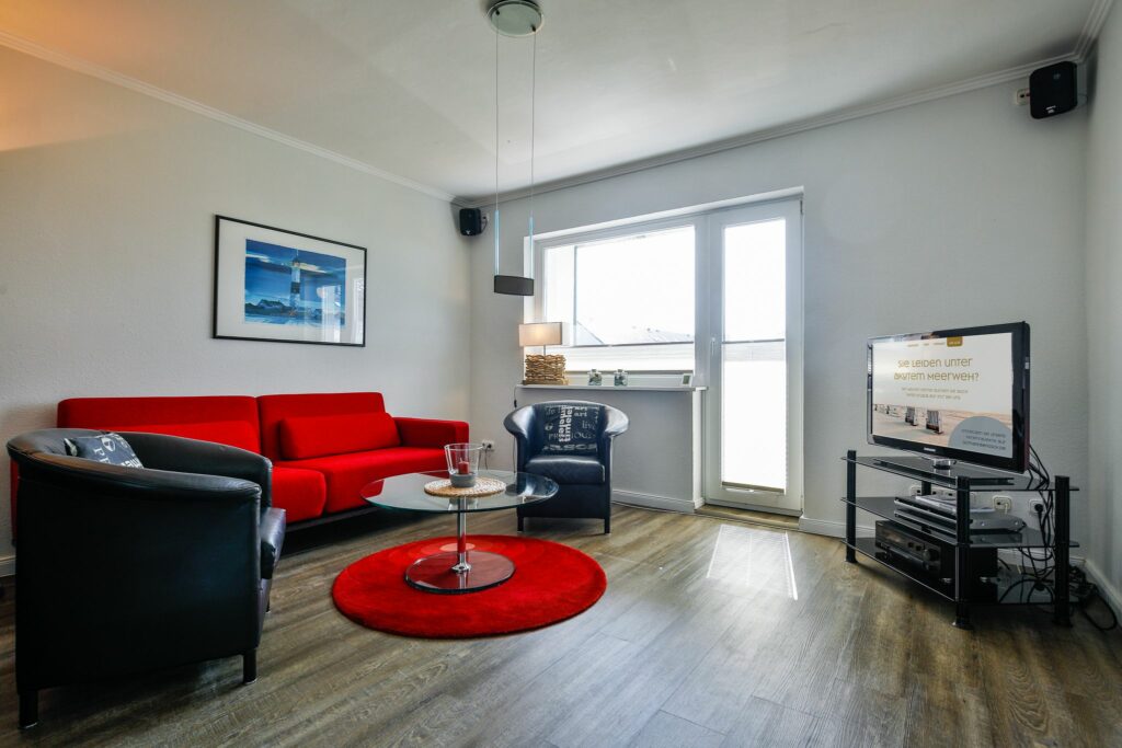 Wohnzimmer mit rotem Sofa in Ferienwohnung Hörnum