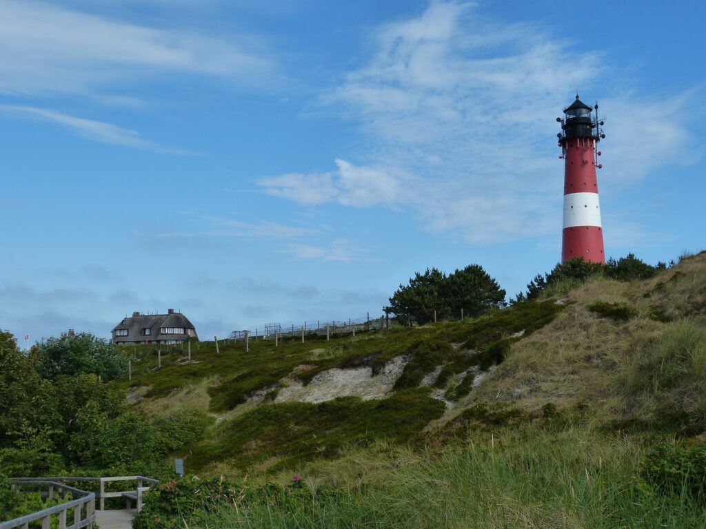 Leuchtturm in den Dünen von Sylt. Der Leuchtturm ist rot-weiß
