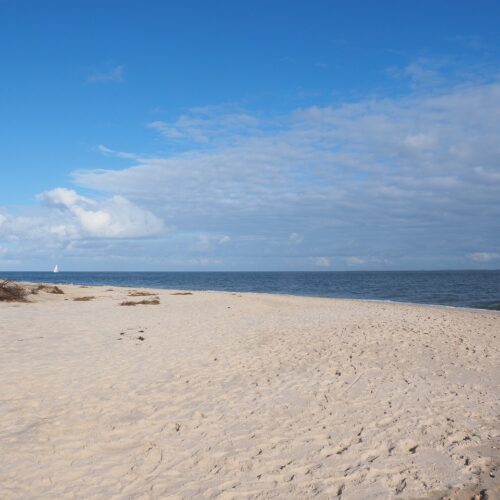 Sandstrand und Meer bei blauen Himmel