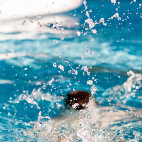 Eine Nahaufnahme von den Wassertropfen die durch einen Sprung ins Wasser entstanden sind.