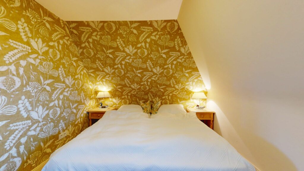 Schlafzimmer mit gemusterter Tapete in Ferienwohnung Hörnum