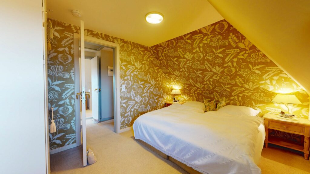 Schlafzimmer mit gemusterter Tapete in Ferienwohnung Hörnum