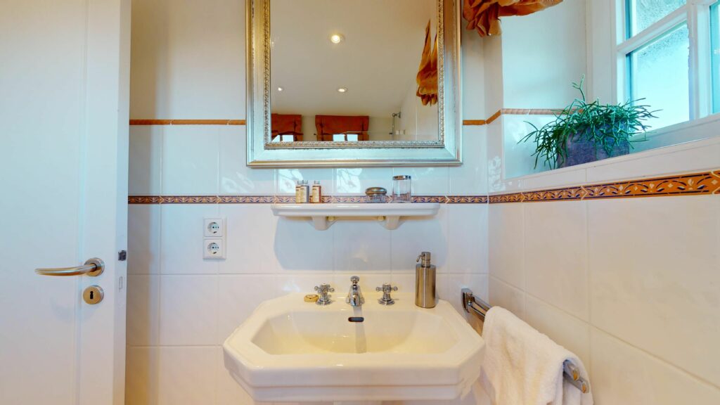 Badezimmer mit Spiegel über dem Waschbecken in Ferienwohnung Hörnum