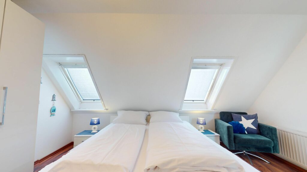 Schlafzimmer mit Doppelbett und maritimer Deko in Ferienwohnung Hörnum