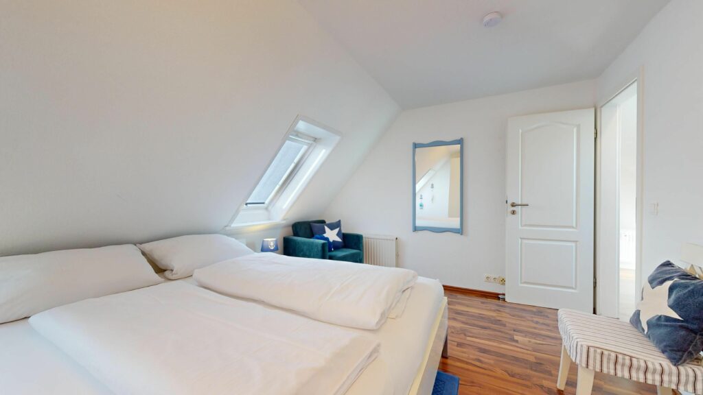 Schlafzimmer mit Doppelbett und maritimer Deko in Ferienwohnung Hörnum