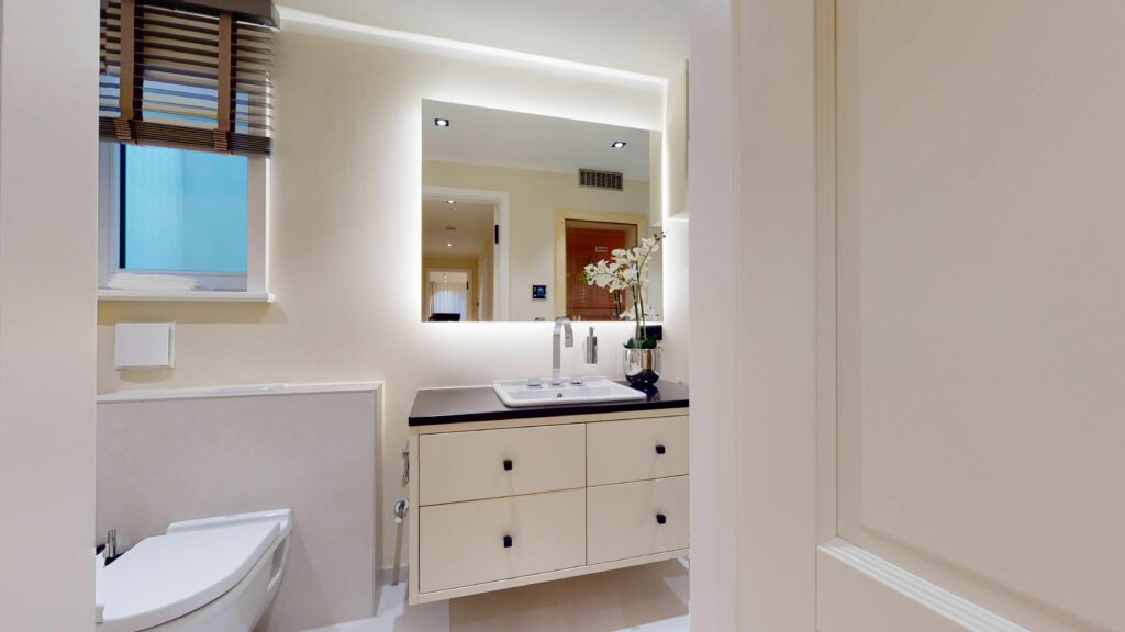 Modernes Waschbecken mit beleuchtetem Spiegel in Ferienwohnung Hörnum