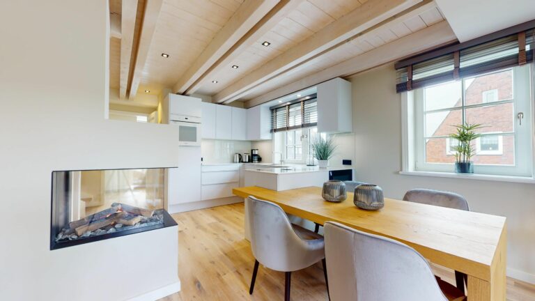 Offene Wohnküche mit Esstisch und Kamin in Ferienwohnung Hörnum