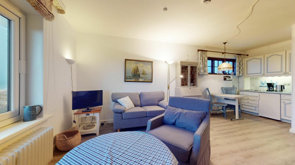 Offene Wohnküche mit blauen Akzenten in Ferienwohnung Hörnum