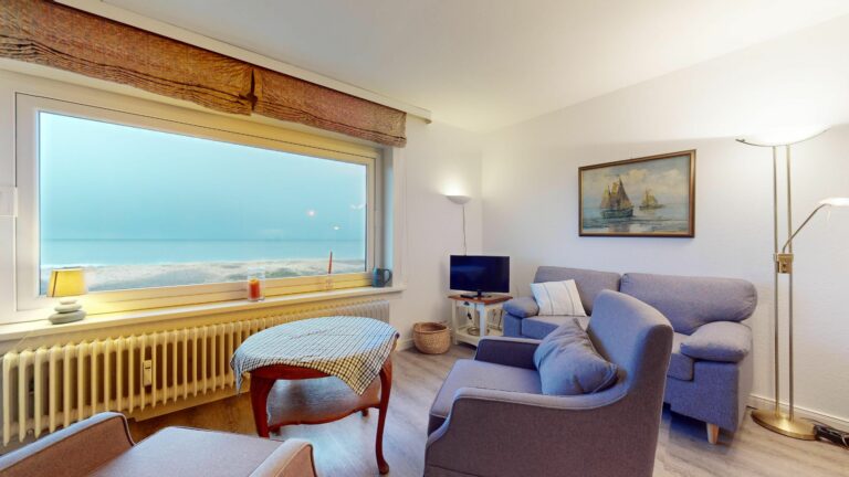 Wohnzimmer mit Panorama Fenster und Meerblick in Ferienwohnung Hörnum