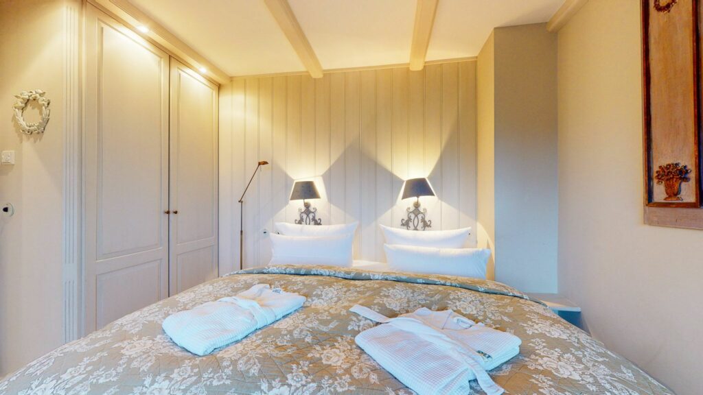 Schlafzimmer mit Doppelbett und Bademänteln in Ferienwohnung Hörnum