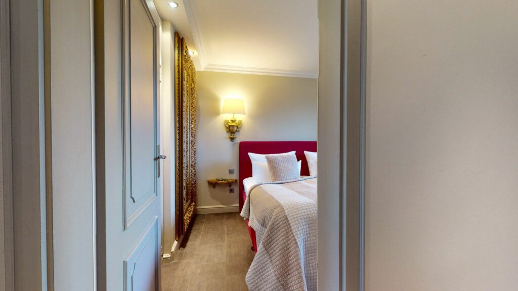 Schlafzimmer mit rotem Doppelbett in Ferienwohnung Hörnum