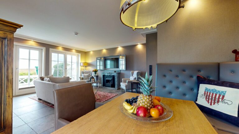 Wohnzimmer mit Esstisch und TV in Ferienwohnung Hörnum