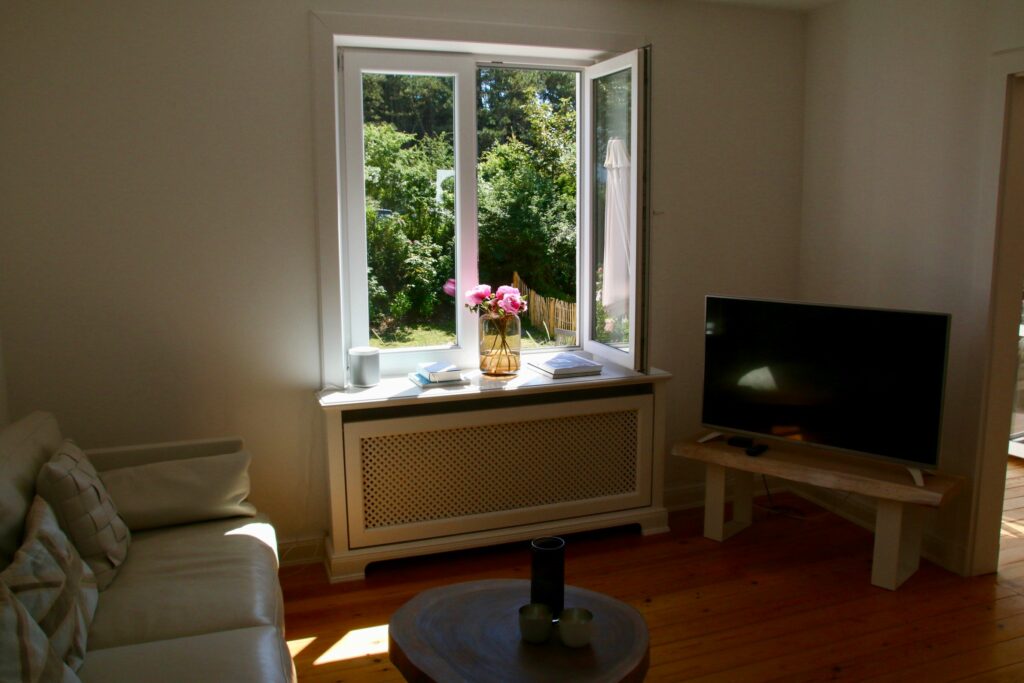 Sofa mit Fernseher und offenen Fenster in Ferienwohnung Hörnum