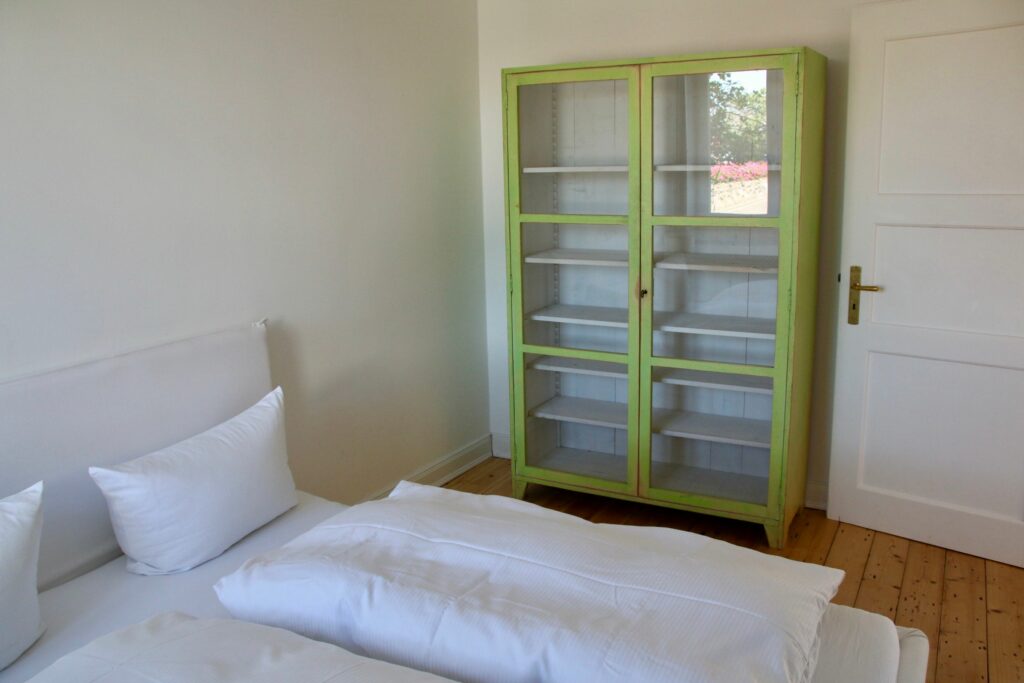 Doppelbett mit grünen Schrank in Ferienwohnung Hörnum