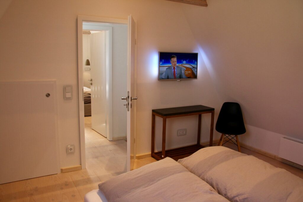 Gemütliches Schlafzimmer mit kleinem Fernseher in Ferienwohnung Hörnum