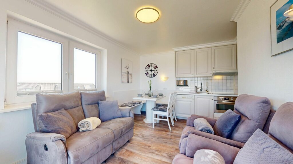 Weiße Küche und lila Sofas und Sessel in Ferienwohnung Hörnum