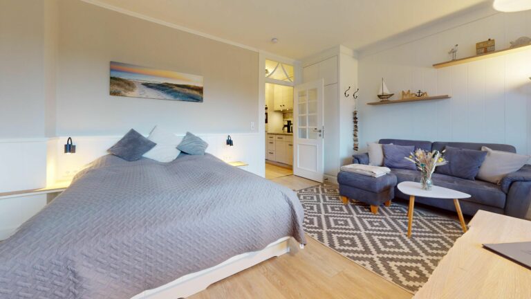 Doppelbett und Sofa in Schlafzimmer in Ferienwohnung auf Sylt