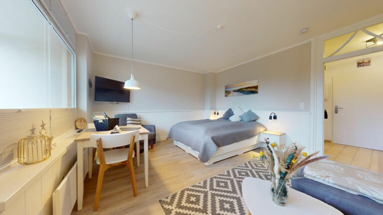 Schlafzimmer mit kleinem Tisch in Ferienwohnung auf Sylt
