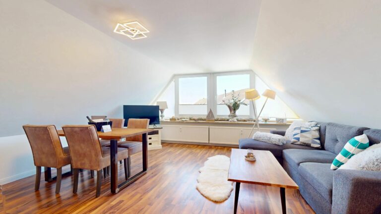 Sofa mit Holztisch und Esstisch in Ferienwohnung auf Sylt