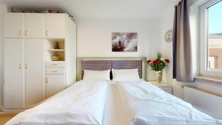 Doppelbett und Wandregal in Ferienwohnung auf Sylt