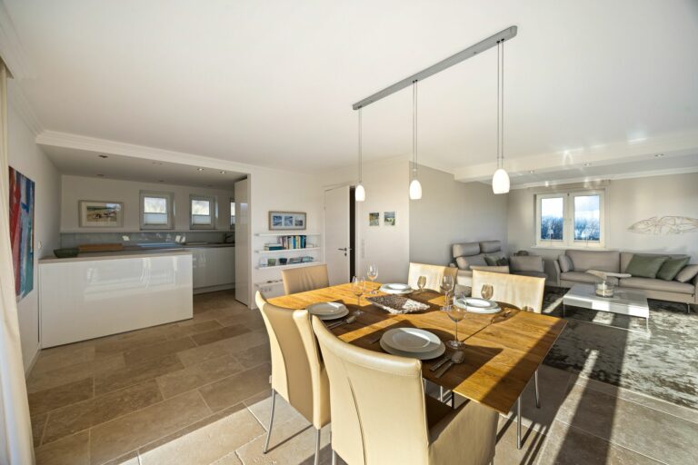 offene Küche und Wohnzimmer mit Esstisch in Ferienwohnung auf Sylt