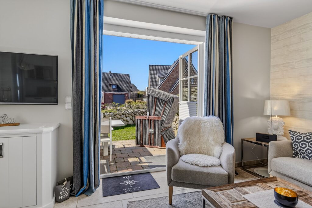 Wohnzimmer und Garten einer Ferienwohnung auf Sylt